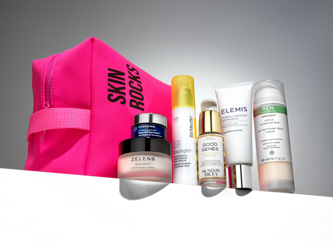 Skin Rocks by Caroline Hirons pink neoprene wash bag with Zelens, Sunday Riley Good Genes, Elemis, REN Evercalm, StriVectin and Dr Dennis Gross skincare — beauty product still life photography by Leo Acker, London Leo Acker Photographer CAROLINE HIRONS / SKIN ROCKS 